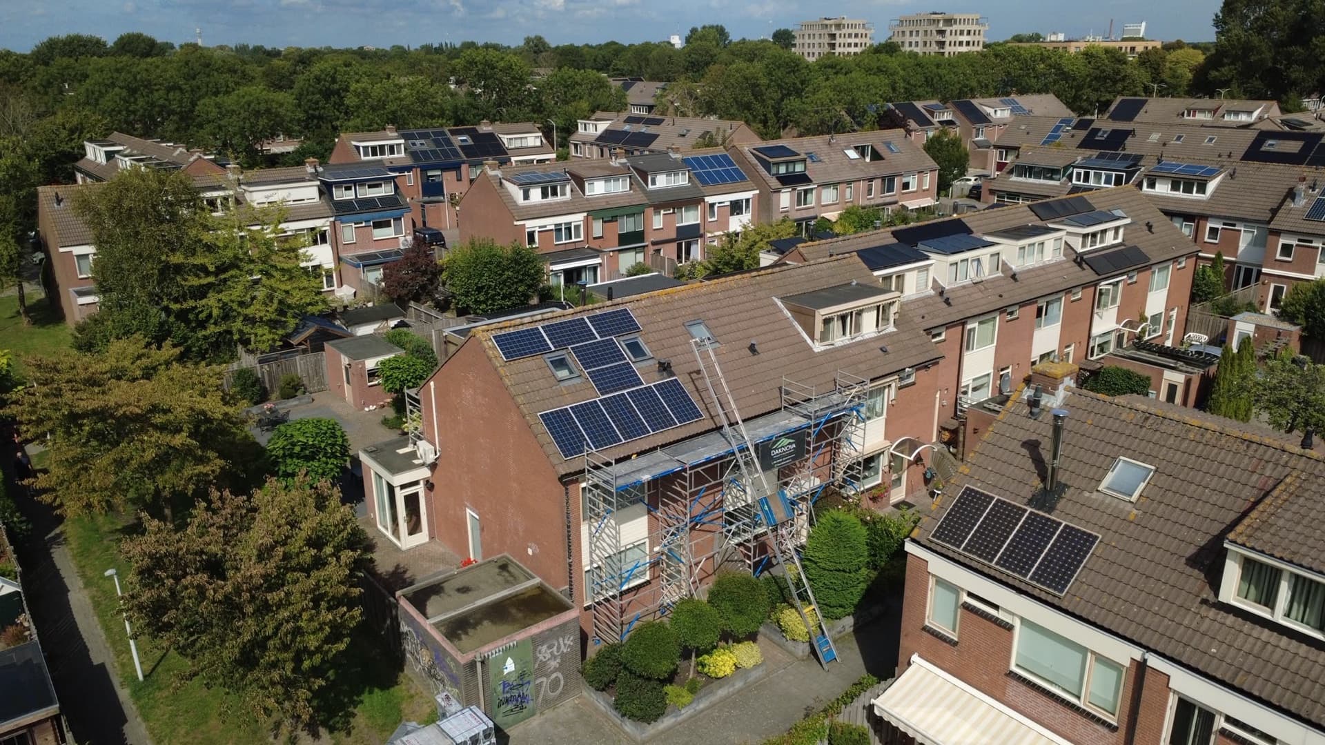 Overzicht vanuit de lucht vóór de dakrenovatie, met de oude zonnepanelen op het dak